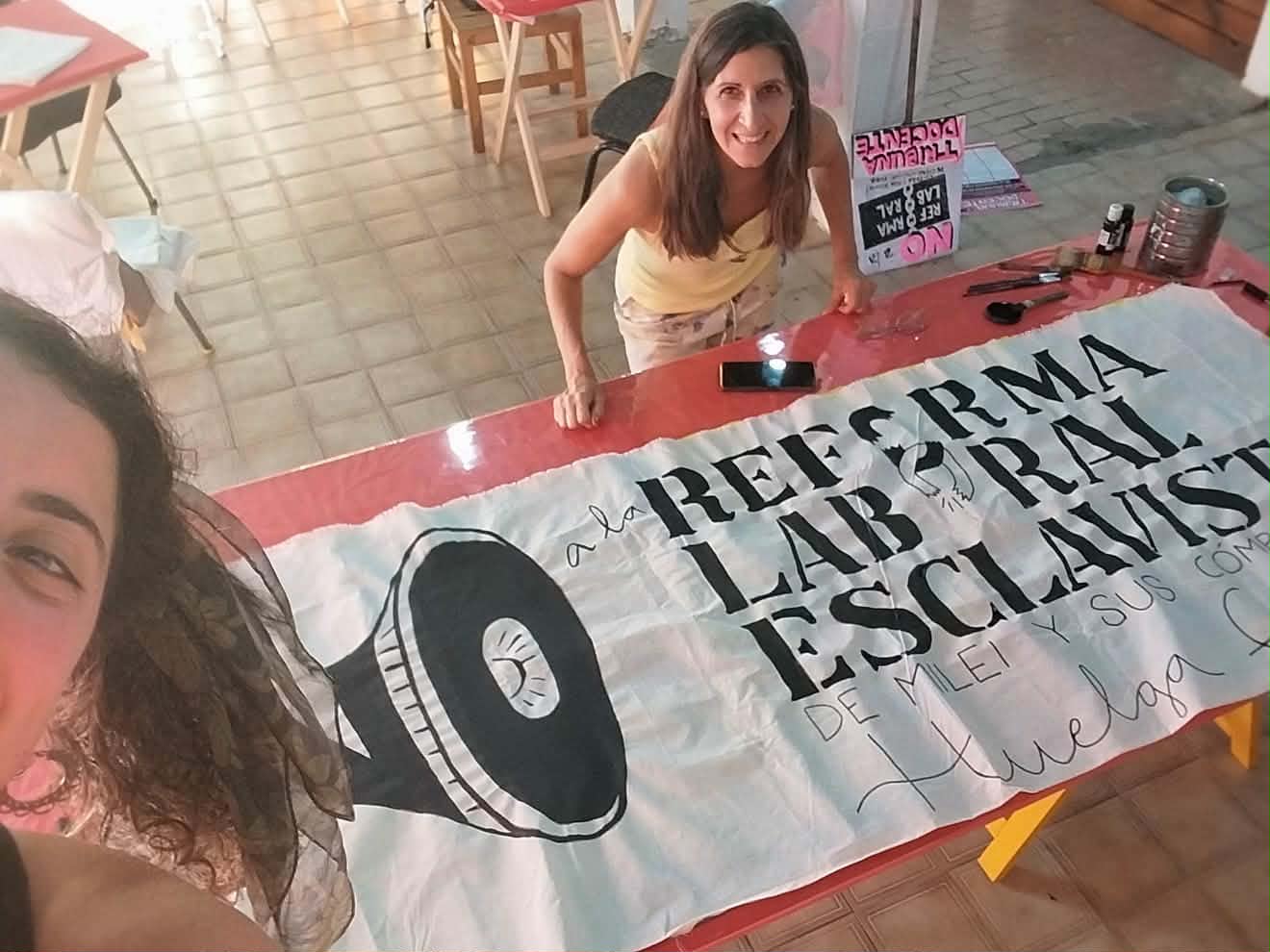 Compañeras pintando una bandera contra la reforma laboral educativa